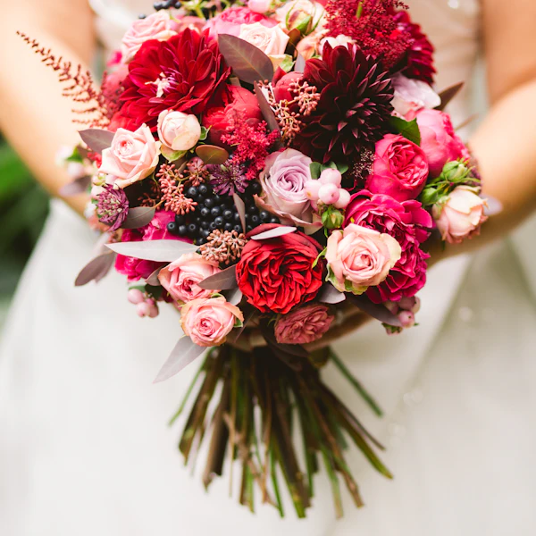 Braut mit einem Strauß in Rot und Rosa