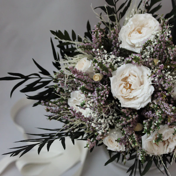 Gebinde aus weißen Rosen, Heide und dunklem Grün