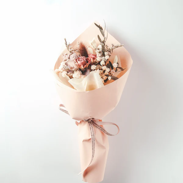 Kleiner Strauß Trockenblumen in Papier mit Schleife